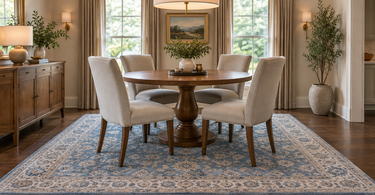 Blue and ivory square 9x9 rug under a 48-inch round dining table with four chairs