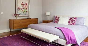 Cozy bedroom featuring a neutral area rug under the bed, adding warmth and texture to the soft-toned interior design.