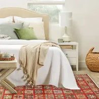 Modern bedroom with a plush area rug under the bed, adding softness and warmth to the cozy, neutral-toned space.