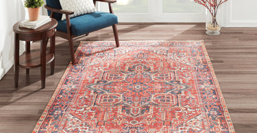 Red and navy Chandler medallion rug in a sunlit reading corner with a blue armchair and small side table