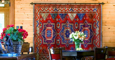 Farmhouse-style living room featuring a large 9x12 neutral rug under a wooden coffee table and linen sofa in a cozy, rustic setting