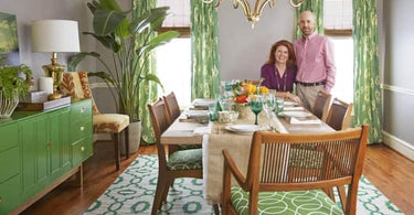 Modern dining room with a patterned area rug under a wooden table, complementing the room's clean, stylish decor