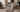 Person blotting a small coffee spill on an ivory and burgundy hand-knotted Persian medallion rug with a white cloth