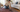Woman vacuuming a red and navy hand-knotted Oriental rug with a suction-only hose attachment in a bright living room