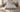 Queen bed with an 8x10 ivory and blue wool rug placed horizontally under the lower two-thirds of the bed, stopping just in front of the nightstands