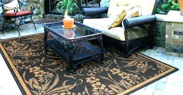 Outdoor polypropylene rug with geometric design styled on a patio under a seating set, offering durability and weather resistance