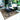 Outdoor polypropylene rug with geometric design styled on a patio under a seating set, offering durability and weather resistance