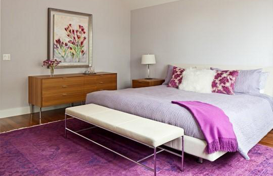 Cozy bedroom featuring a neutral area rug under the bed, adding warmth and texture to the soft-toned interior design.