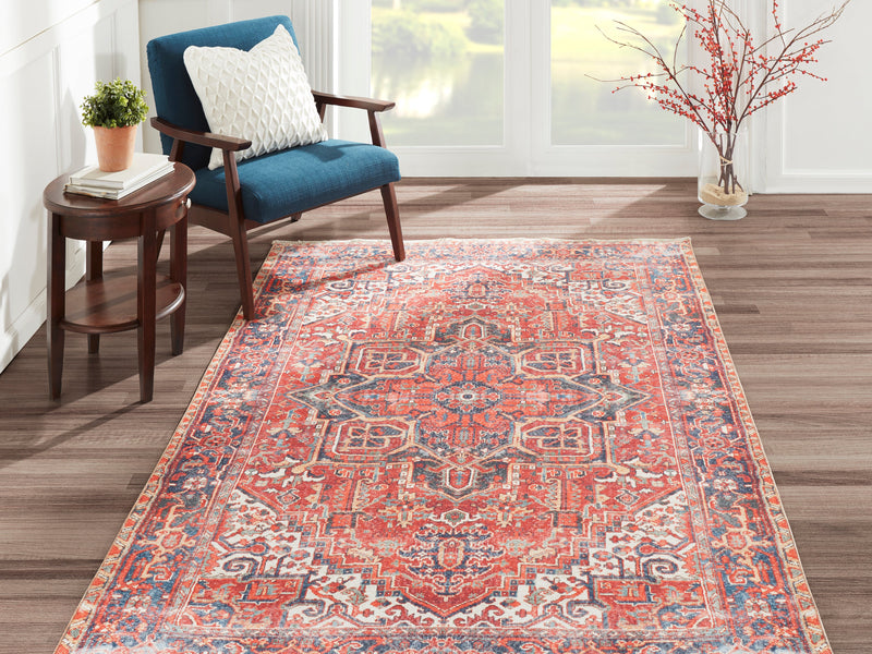 Red and navy Chandler medallion rug in a sunlit reading corner with a blue armchair and small side table