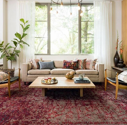 Side-by-side view of a modern geometric rug and a traditional Persian-style rug placed in two different living room settings