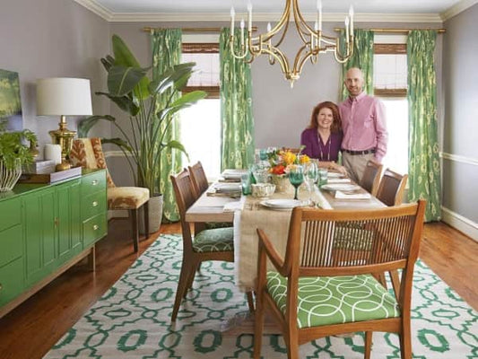 Modern dining room with a patterned area rug under a wooden table, complementing the room's clean, stylish decor