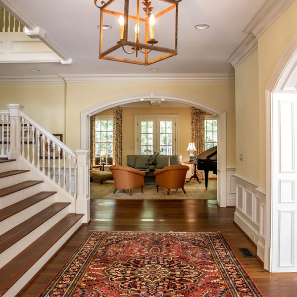 Traditional Persian area rug with intricate red and gold design in elegant living room