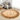 Person measuring the diameter of a round rug in a bright living room with a measuring tape