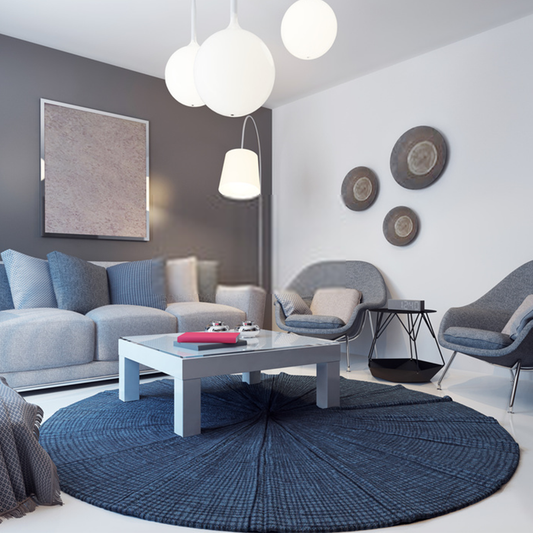 Modern round rug placed under a small coffee table with matching decor in a minimalist living room setting