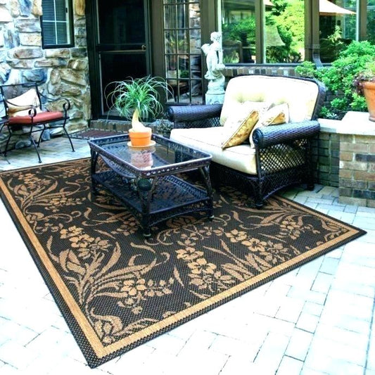 Outdoor polypropylene rug with geometric design styled on a patio under a seating set, offering durability and weather resistance
